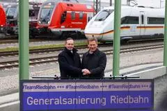 Sperrungs-Ende: Minister Wissing lässt Riedbahn wieder rollen - Nach fünfmonatiger Vollsperrung soll es auf der Riedbahn wieder Fahrsignale für den Zugverkehr geben. Damit endet die erste Korridor-Gesamtsanierung, die zum Modell für die Neuaufstellung der Deutschen Bahn werden soll. Verkehrsminister Wissing und Bahn-Chef Lotz kommen nach Gernsheim, um die Strecke freizugeben. Was die Sperrung und ihre Begleiterscheinung für die Region bedeuteten.  Verkehrsminister Volker Wissing und DB-Chef Richard Lutz drücken den Buzzer.