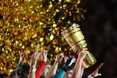 Fußball: DFB-Pokal, RB Leipzig - Eintracht Frankfurt, Finale, Olympiastadion. Die Leipziger Spieler halten die Siegertrophäe in die Höhe. WICHTIGER HINWEIS: Gemäß den Vorgaben der DFL Deutsche Fußball Liga bzw. des DFB Deutscher Fußball-Bund ist es untersagt, in dem Stadion und/oder vom Spiel angefertigte Fotoaufnahmen in Form von Sequenzbildern und/oder videoähnlichen Fotostrecken zu verwerten bzw. verwerten zu lassen. +++ dpa-Bildfunk +++