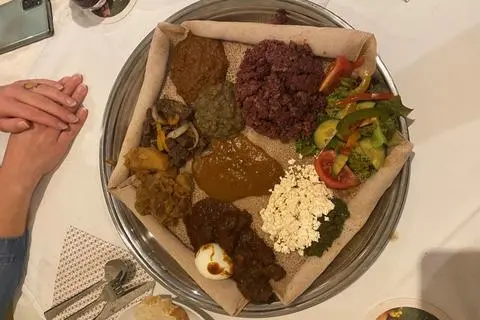 Auf einer silbernen Platte liegen zehn verschiedene Gerichte auf dem "Injera" Schwammbrot.  Loana Schnitzspahn