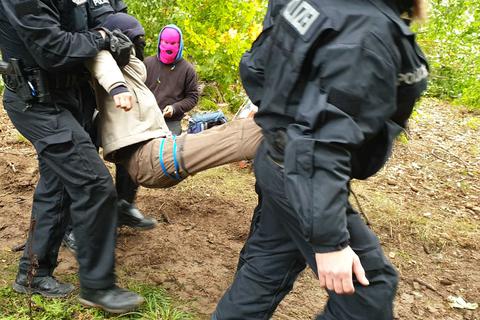 Polizisten tragen einen Demonstranten weg, der im Herrenwald bei Stadtallendorf gegen die Rodung von Bäumen für den Ausbau der A49 protestierte.    Archivfoto: dpa