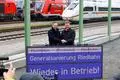 Sperrungs-Ende: Minister Wissing lässt Riedbahn wieder rollen - Nach fünfmonatiger Vollsperrung soll es auf der Riedbahn wieder Fahrsignale für den Zugverkehr geben. Damit endet die erste Korridor-Gesamtsanierung, die zum Modell für die Neuaufstellung der Deutschen Bahn werden soll. Verkehrsminister Wissing und Bahn-Chef Lotz kommen nach Gernsheim, um die Strecke freizugeben. Was die Sperrung und ihre Begleiterscheinung für die Region bedeuteten.  Verkehrsminister Volker Wissing und DB-Chef Richard Lutz drücken den Buzzer.