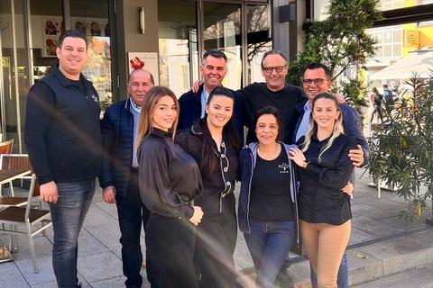 Luciano Riva (hinten, 2.v.r.) verabschiedet sich, Hetem Djaferi (l.) und sein Team übernehmen das Eis-Café „Piccin“ in Nieder-Olm.