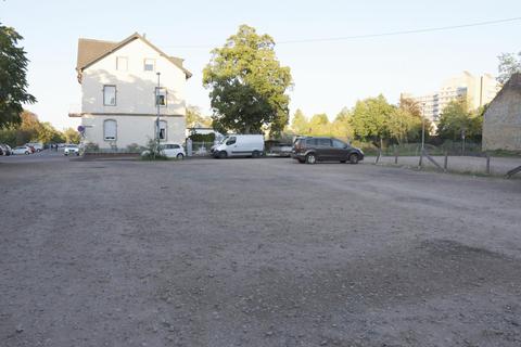 Zwischen dem Wohnhaus an der Ecke zum Kohleweg (l.) und dem Diakonie-Gelände mit Fachschulzentrum (r.), dort, wo die Bäume eine Wiese zur Fliedner-Halle begrenzen, wird die inklusive Grundschule errichtet. Der bisherige Schotterparkplatz markiert die Stelle, an dem sich künftig der Schulhof befinden soll. Foto: Isabel Mittler