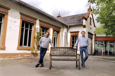 Frank Koslowski (links) und Bernd Breitwieser stellen im Hof der Bessunger Knabenschule schon mal symbolisch eine Bank für die ersten Besucher des Kulturzentrums auf. Foto: Andreas Kelm 