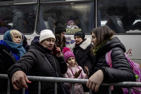 Flüchtlinge aus der Ukraine warten in Korczowa im polnisch-ukrainischen Grenzgebiet darauf, mit Nahrung und Kleidung versorgt und dann in Sicherheit gebracht zu werden.  Foto: dpa
