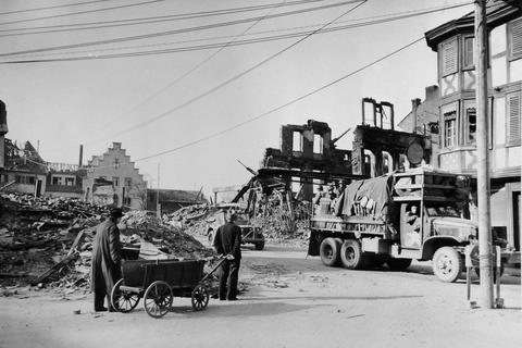 18. März 1945: Zwei Bad Kreuznacher warten, bis ein US-Fahrzeug den zerbombten Kornmarkt passiert hat. Fotos: Stars & Stripes Sammlung Heinz Liewig