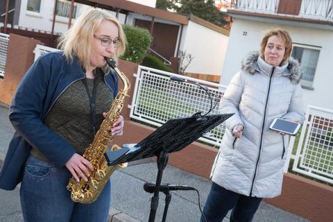 Lea Held am Saxofon und ihre Mutter Christiane beteiligen sich – mit dem gebotenen Sicherheitsabstand – in der Siegfriedstraße an den Konzerten. Foto: Thorsten Gutschalk