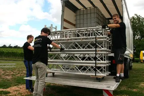 Firmeninhaber Jonas Koch (re) entlädt mit seinem Team Bühnenbau-Teile am Nussbaum-Gelände. Neu ist der Ehrenamtspokal bei der Binger Sommernacht.