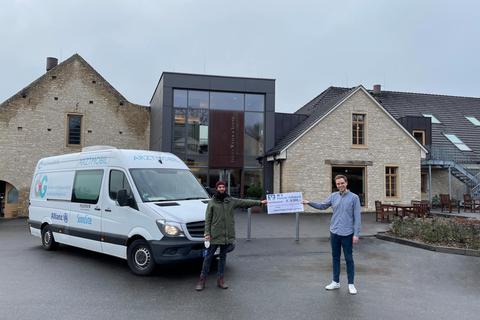 Jari Trabert (li.) vom Verein „Armut und Gesundheit in Deutschland“ nimmt den Spendenscheck von Gerhard Wasem in Höhe von 8000 Euro entgegen. Foto: Weingut Wasem