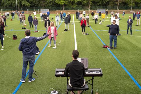 Der Klein-Winternheimer Sportplatz hat sich in einen Open-Air-Probenraum für den bekannten Pop- und Gospelchor verwandelt. Foto: hbz/Stefan Sämmer
