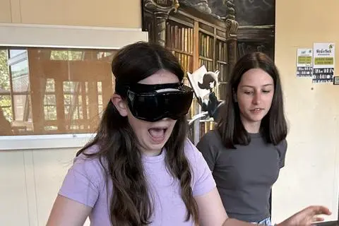 Ida Aimée Donges testet die Alkoholsimulationsbrille, Marlena Teutsch steht ihr als Helferin zur Seite.