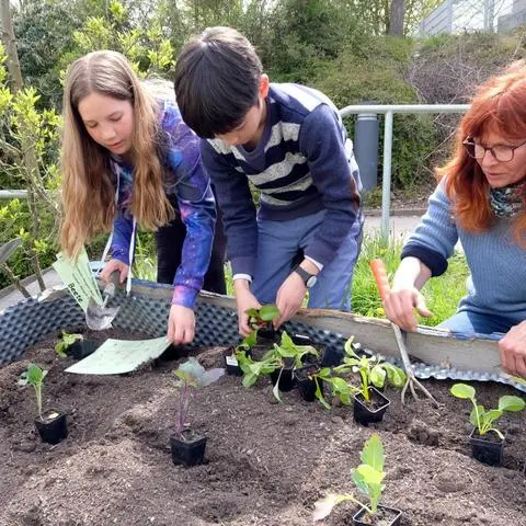 Lehrerin Nicole Sachs ist mit Schülern am Hochbeet zugange.