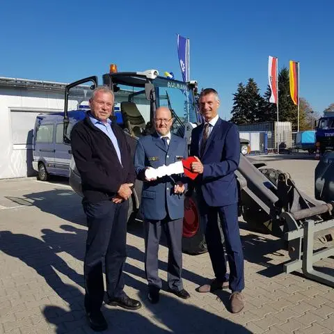 Rheingau-Taunus-Landrat Frank Kilian (parteilos) übergibt einen Radlader an den Ortsbeauftragten des THW-Ortsverbandes Geisenheim/Lorch, Michael Göttert (Mitte). Links Kreisbrandmeister Reiner Oswald von Fachdienst Brand- und Katastrophenschutz/Rettungsdienst der Kreisverwaltung.