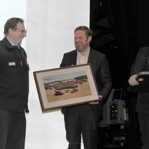 Stadtbrandinspektor Martin Zywitza (am Rednerpult) und seine Stellvertreter Thorsten Hilz (links) und Hans-Joachim Hippler bedanken sich mit einem Abschiedsgeschenk bei Bürgermeister Sandro Zehner (Bildmitte).