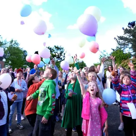 Kinder lassen beim Fest der Versöhnung in Wehen Ballons, an die sie Fürbitten gebunden haben, in die Luft steigen.