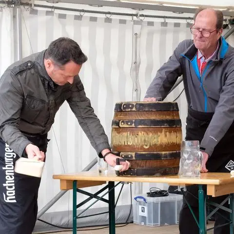 Sechs Schläge braucht Bürgermeister Joachim Reimann (CDU) bei seiner ersten Eröffnung des Weher Marktes beim Fassbieranstich. Unterstützung gibt es vom Ortsvorsteher Gerhard Schmittel (CDU).