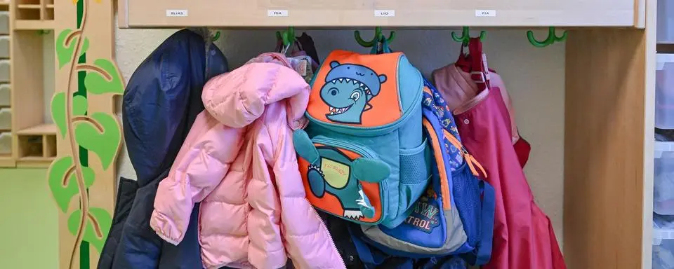 ARCHIV - 22.12.2023, Brandenburg, Spremberg: Kleidung von Kindern hängt in einer Kita / Kindergarten. (zu dpa: «Bildungsministerium will bei Kita-Personalverordnung nachbessern») Foto: Patrick Pleul/dpa +++ dpa-Bildfunk +++
