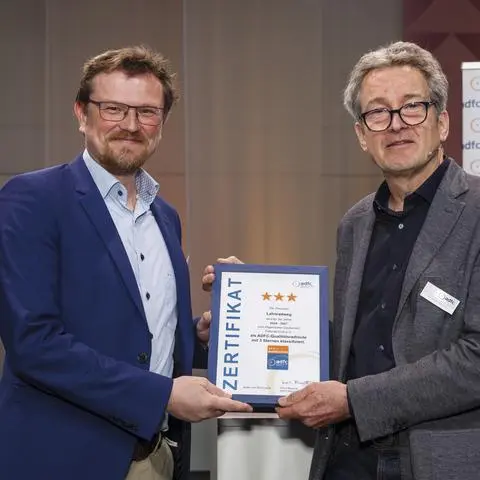 Philipp Borchardt (l.), Geschäftsführer des Lahntal Tourismus Verbands, erhält von ADFC-Tourismusvorstand Christian Tänzler die Urkunde für die Drei-Sterne-Klassifizierung der Qualitätsradroute Lahnradweg.