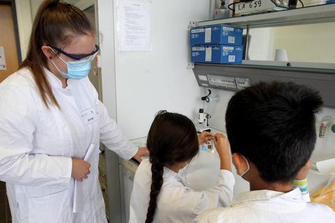 An den Labortischen finden die kleinen Forscher diverse Substanzen in verschlossenen Gläsern. Anne Frölich (l.) betreut die Kinder beim Experimentieren. Foto: hbz/Jörg Henkel