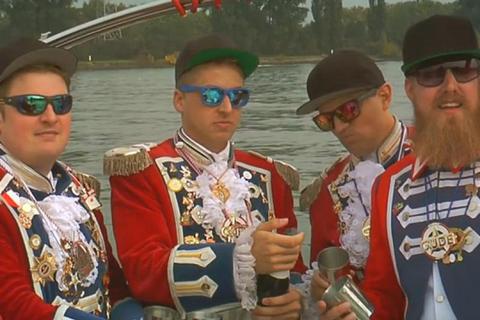 Mit Sekt und Vollgas über den Rhein: Kann man alles machen, wenn man die richtige Uniform hat. Das zeigt das Persiflage-Video der RotRockRapper der Mainzer Prinzengarde. Screenshot: VRM 