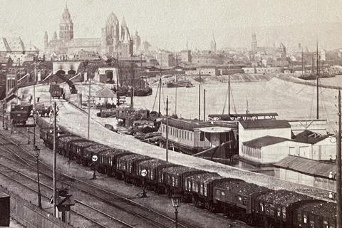 Blick vom Winterhafen auf die Stadt zum Festungswall mit der Eisenbahndurchfahrt und dem dahinter liegenden Bahnhof mit den Befestigungen am Rhein. Das Foto lässt sich auf die 1860er datieren, denn der Dom trägt noch die 1870 abgebrochene Mollerkuppel.