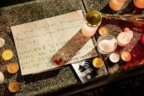Ein Papier mit der Botschaft ·...und stiftet Frieden zwischen allen Menschen! Unsere Gedanken sind bei den Toten und dessen Angehörigen!" ist bei einer Solidaritätskundgebung anlässlich des Attentats in Halle (Saale) an der Neuen Synagoge Berlin neben Kerzen zu sehen.  Foto: dpa