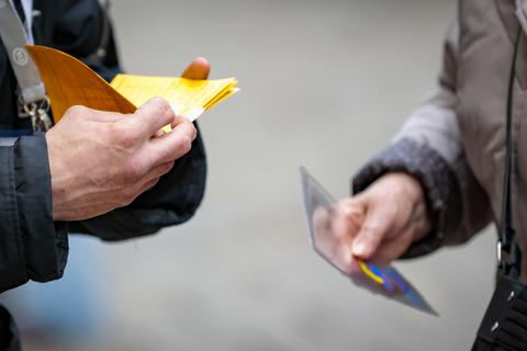 Ein Mann kontrolliert einen Impfpass. Seit der Verschärfung der Corona-Regeln floriert der Handel mit gefälschten Impfnachweisen. Foto: Sascha Kopp
