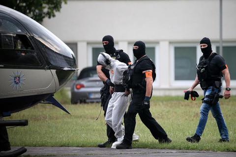 Auf dem Weg in die Untersuchungshaft: Ali B. wird in Wiesbaden von Beamten einer polizeilichen Spezialeinheit aus dem Justizzentrum zu einem Polizeihubschrauber gebracht.Foto: dpa  Foto: dpa