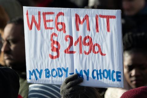 Teilnehmer einer Demonstration zum Internationalen Frauentag gehen durch Mitte und halten dabei ein Schild mit der Aufschrift "Weg mit Paragraf 219a - My Body - my Choice". dpa
