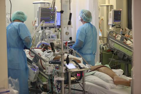 Zwei Intensivpfleger versorgen einen Covid-19-Patienten auf der Intensivstation einer Uniklinik. Foto: dpa/Jan Woitas