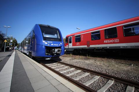 Neben einem Regionalexpresszug der Firma vlexx steht ein Regionalzug der Deutschen Bahn.