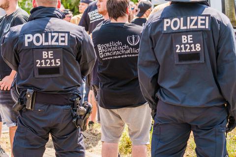 Ein Demonstrant steht bei einer Demo der rechtsextremen „Neue Stärke Partei“ (NSP) in Mainz zwischen zwei Polizisten.