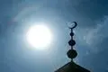Blick auf den Halbmond auf dem Minarett einer Moschee.