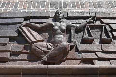 Blick auf die Justitia über dem Eingang eines Landgerichts.
