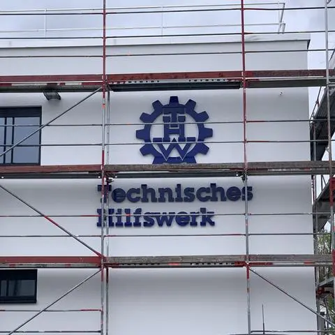 Das blaue Logo des Technischen Hilfswerkes hängt bereits an der neuen Halle.