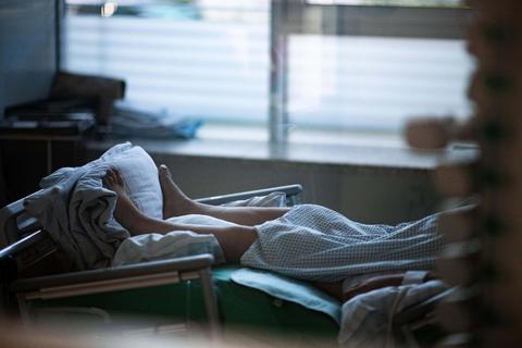 Ein Patient liegt in einem Zimmer auf einer Corona-Intensivstation.