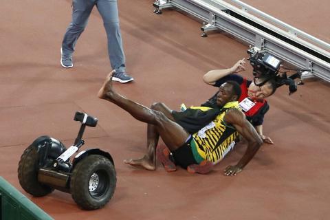 Usain Bolt am Boden! - Ach nein, der jamaikanische Doppelweltmeister ist in Peking beim Jubeln lediglich mit einem chinesischen Kameramann auf einem Segway zusammengestoßen. Wahre Geschichte! Foto: dpa