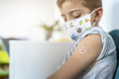 Ein Junge trägt nach einer Impfung ein Pflaster auf dem Oberarm. Foto: Albert - stock.adobe
