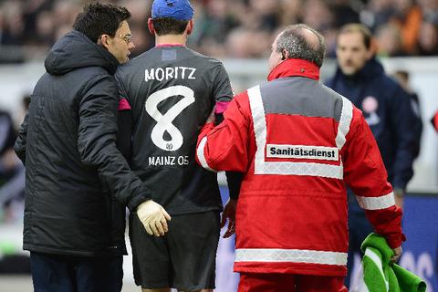 Der verletzte Christoph Moritz geht mit blauem Kopfverband vom Feld. Luiz Gustavo von Wolfsburg hatte den Mainzer Defensivspieler unglücklich mit dem Schuh am Kopf getroffen. Foto: dpa