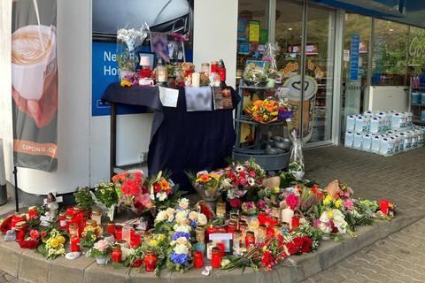 Blumen und Kerzen sind vor der Tankstelle in Idar-Oberstein aufgestellt, in der ein Angestellter von einem 49-jährigen Mann erschossen wurde. Foto: dpa 