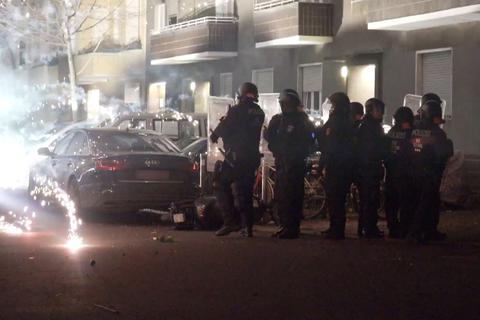 Polizeibeamte hinter explodierendem Feuerwerk in Berlin. Nach Angriffen auf Einsatzkräfte hat die Diskussion um Konsequenzen begonnen.