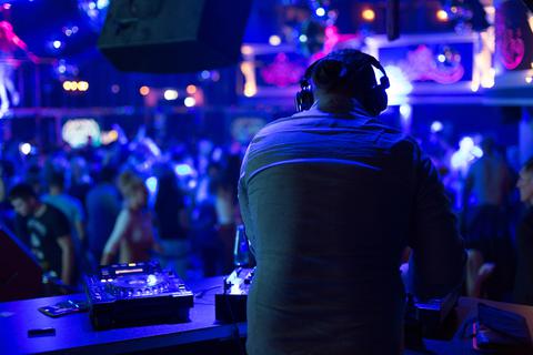 Ein DJ legt in einem Club Musik auf. Foto: dpa