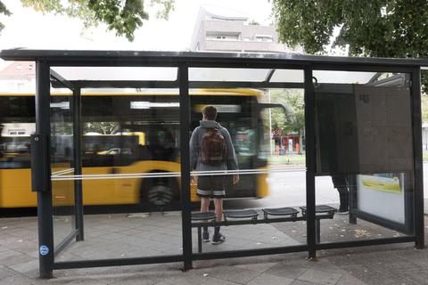 Ein Bus hält an einer Bushaltestelle.