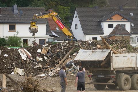 Bagger laden Bauschutt und Treibgut auf Lastwagen in dem von der Hochwasserkatastrophe zerstörten Ort Kreuzberg. Foto: dpa