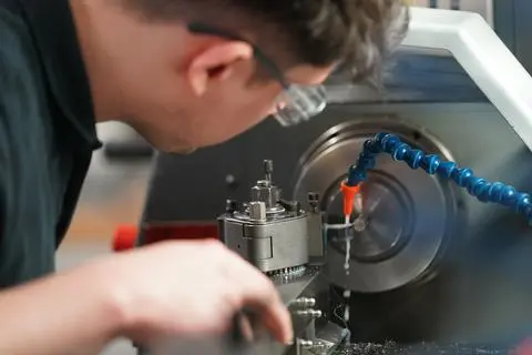 Ein Auszubildender arbeitet an einer Drehmaschine