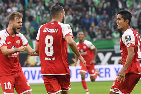 Yoshinori Muto (r.) von Mainz 05 bejubelt sein Tor zum 1:1 gegen den VfL Wolfsburg mit Alexandru Maxim (l.) und Levin Öztunali. Foto: dpa