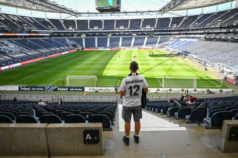 Ein Fan von Eintracht Frankfurt blickt auf das Stadion. Foto: dpa