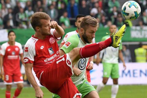 Wolfsburgs Jakub Blaszczykowski (rechts) und der Mainzer Daniel Brosinski kämpfen um den Ball. Foto: dpa 
