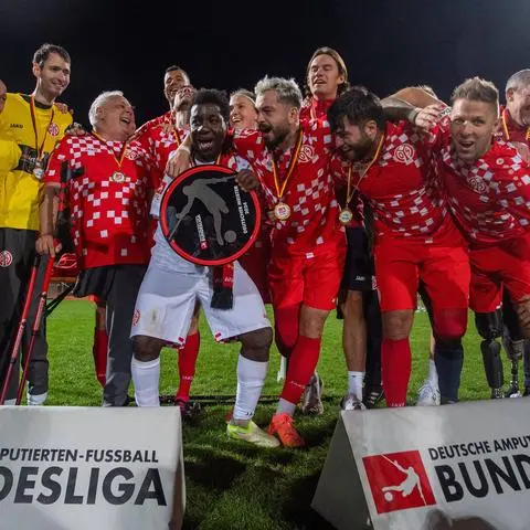 Da ist das Ding! Die Amputierten-Fußballer des FSV Mainz 05 um die Trainer Jürgen Menger, Jörg Schmidtke und Detlef Boche mit der Meisterschale bei der Siegerehrung in Berlin.