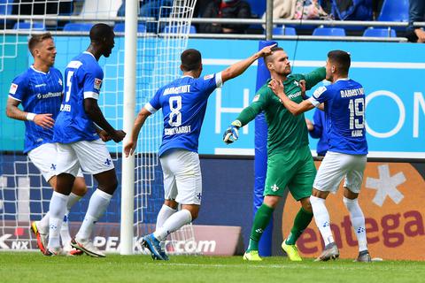 Darmstadt 98-Keeper Marcel Schuhen hält gegen Hannover 96 einen Elfmeter und wird von seinen Mitspielern entsprechend gefeiert. Foto: Florian Ulrich